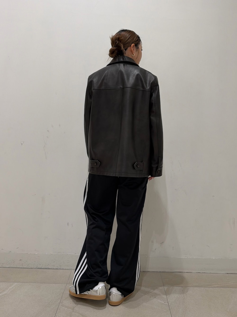 ブラック系のブルゾン、ホワイト系のTシャツ/カットソー、シルバー系のスニーカーを着用したレディースの冬コーディネートの2枚目の写真