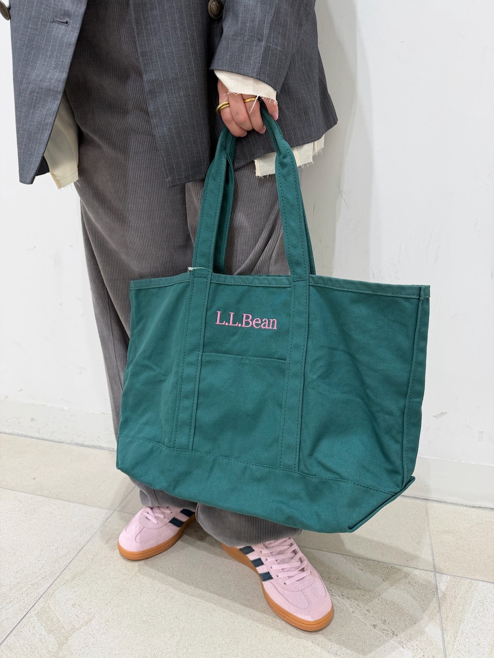 グレー系のテーラードジャケット、ホワイト系のTシャツ/カットソー、グリーン系のトートバッグを着用したレディースの冬コーディネートの5枚目の写真