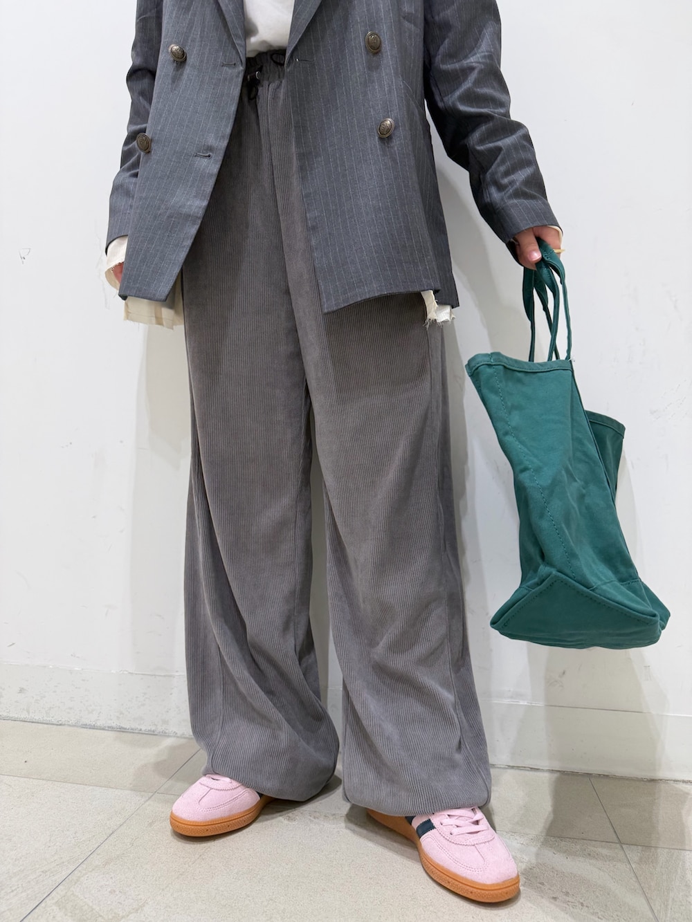 グレー系のテーラードジャケット、ホワイト系のTシャツ/カットソー、グリーン系のトートバッグを着用したレディースの冬コーディネートの4枚目の写真