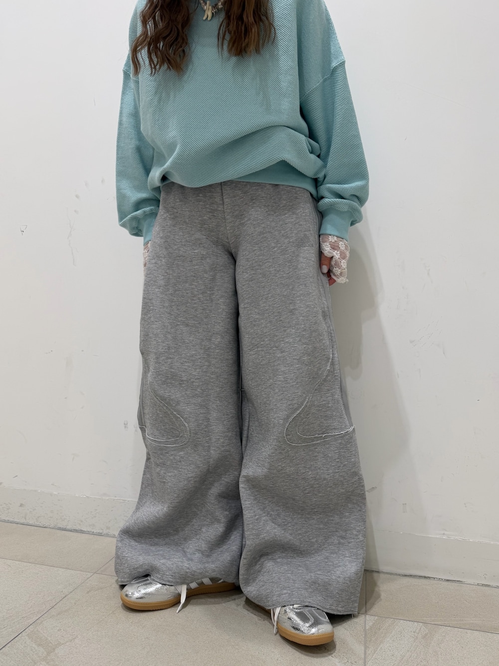 ブルー系のスウェット、ホワイト系のTシャツ/カットソー、シルバー系のスニーカーを着用したレディースの冬コーディネートの3枚目の写真