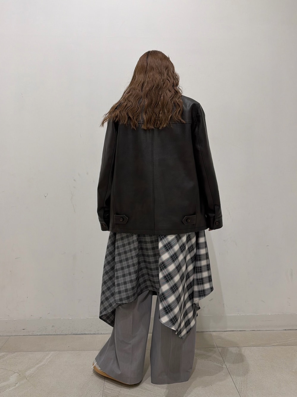 ブラック系のブルゾン、ブラック系のワンピース、シルバー系のスニーカーを着用したレディースの冬コーディネートの5枚目の写真