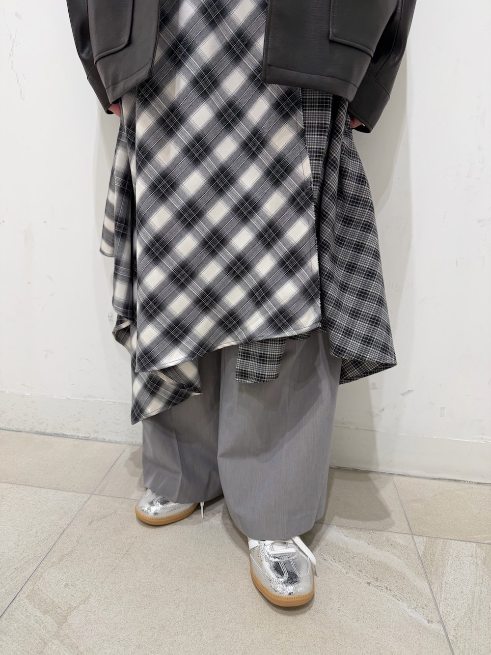 ブラック系のブルゾン、ブラック系のワンピース、シルバー系のスニーカーを着用したレディースの冬コーディネートの3枚目の写真