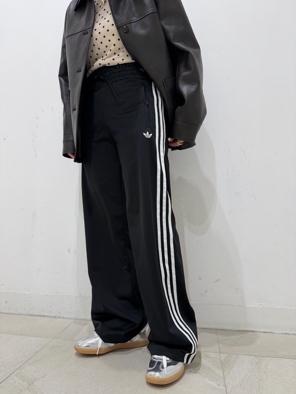 ブラック系のブルゾン、ホワイト系のTシャツ/カットソー、シルバー系のスニーカーを着用したレディースの冬コーディネートの3枚目の写真