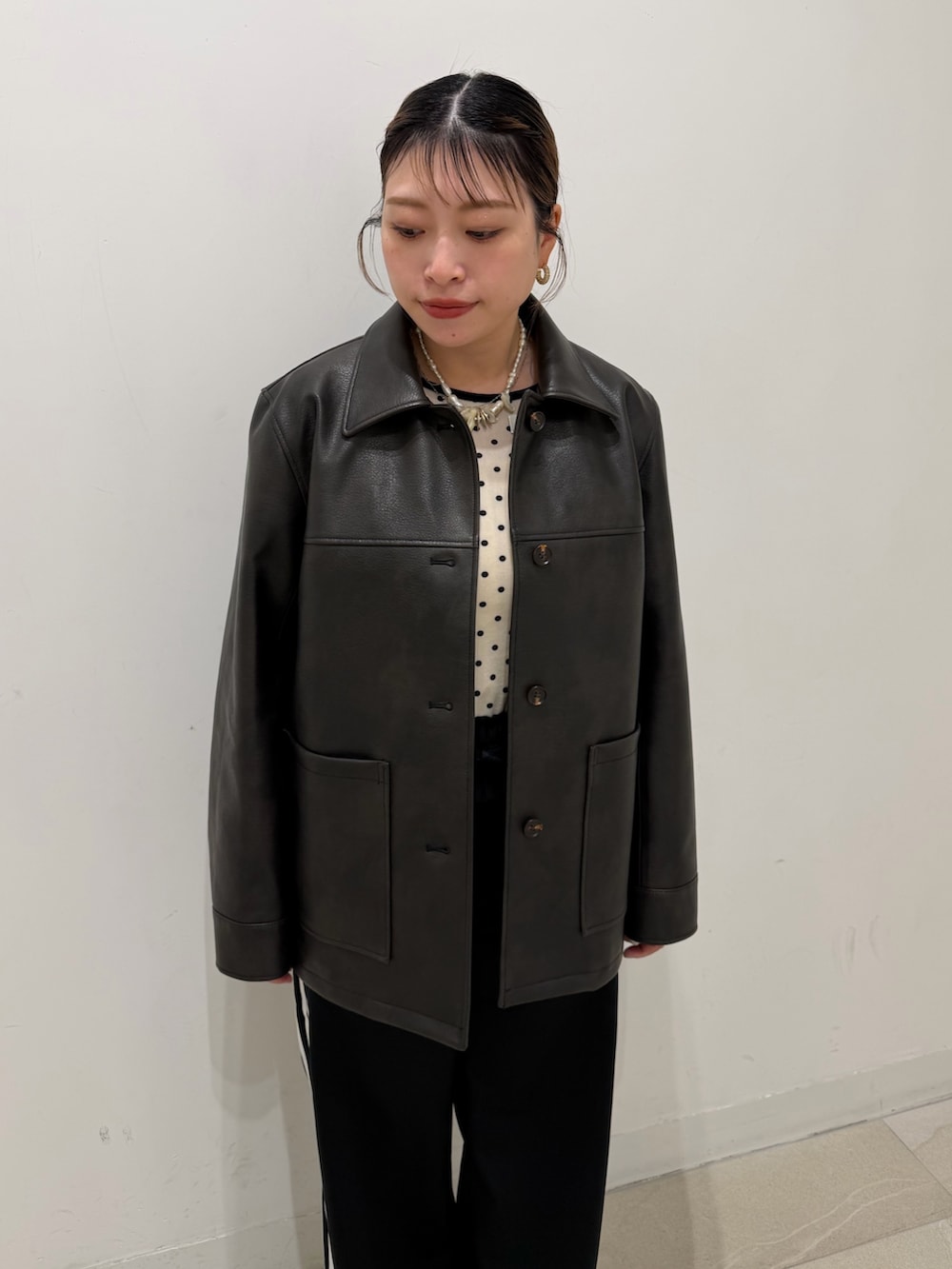 ブラック系のブルゾン、ホワイト系のTシャツ/カットソー、シルバー系のスニーカーを着用したレディースの冬コーディネートの4枚目の写真