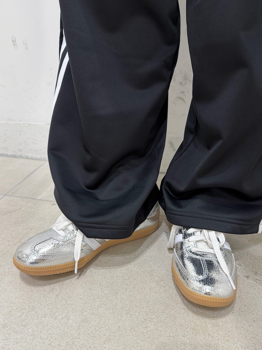 ブラック系のブルゾン、ホワイト系のTシャツ/カットソー、シルバー系のスニーカーを着用したレディースの冬コーディネートの5枚目の写真