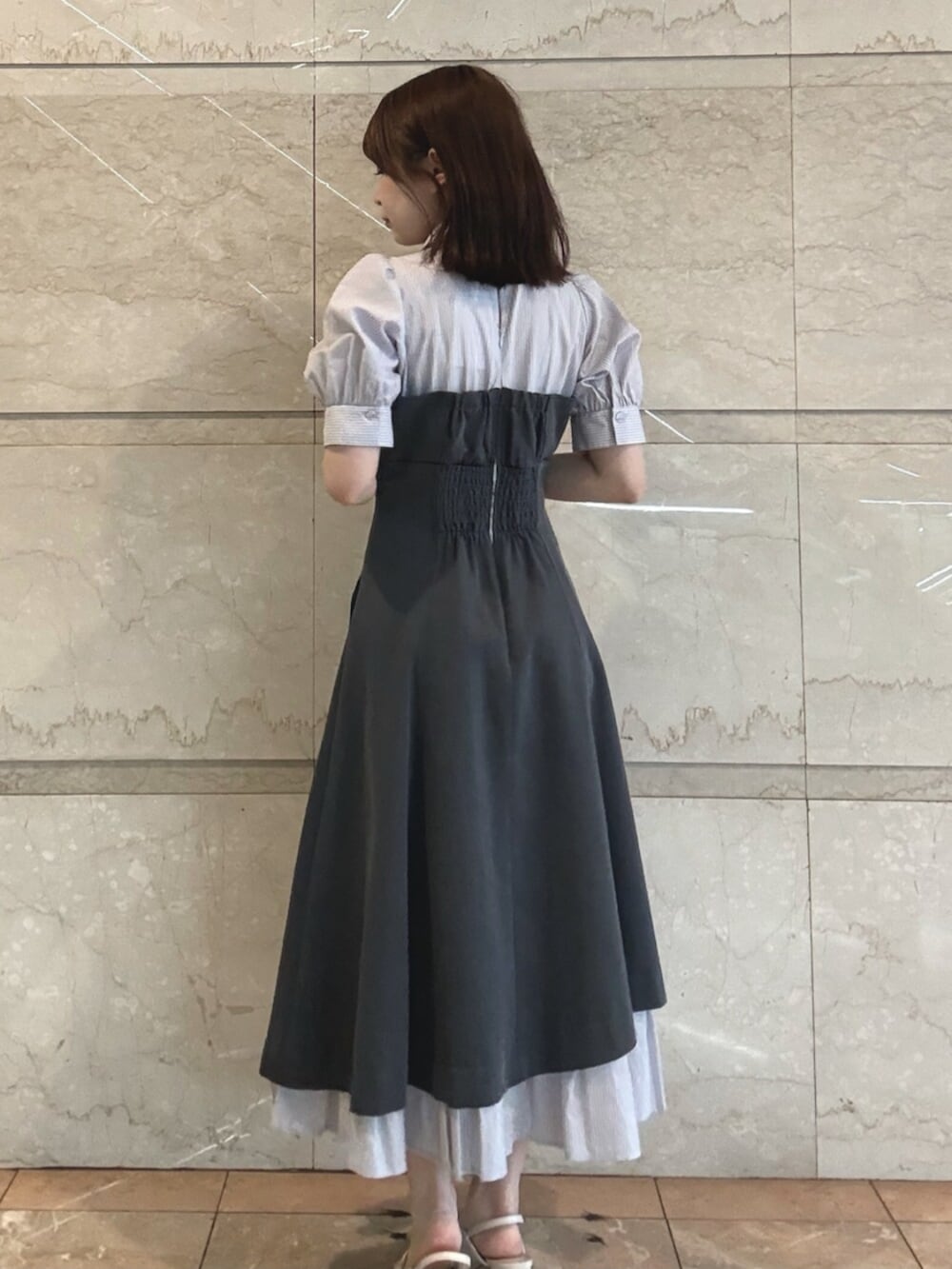 ホワイト系のパンプス、グレー系のワンピースを着用したレディースの春コーディネートの4枚目の写真