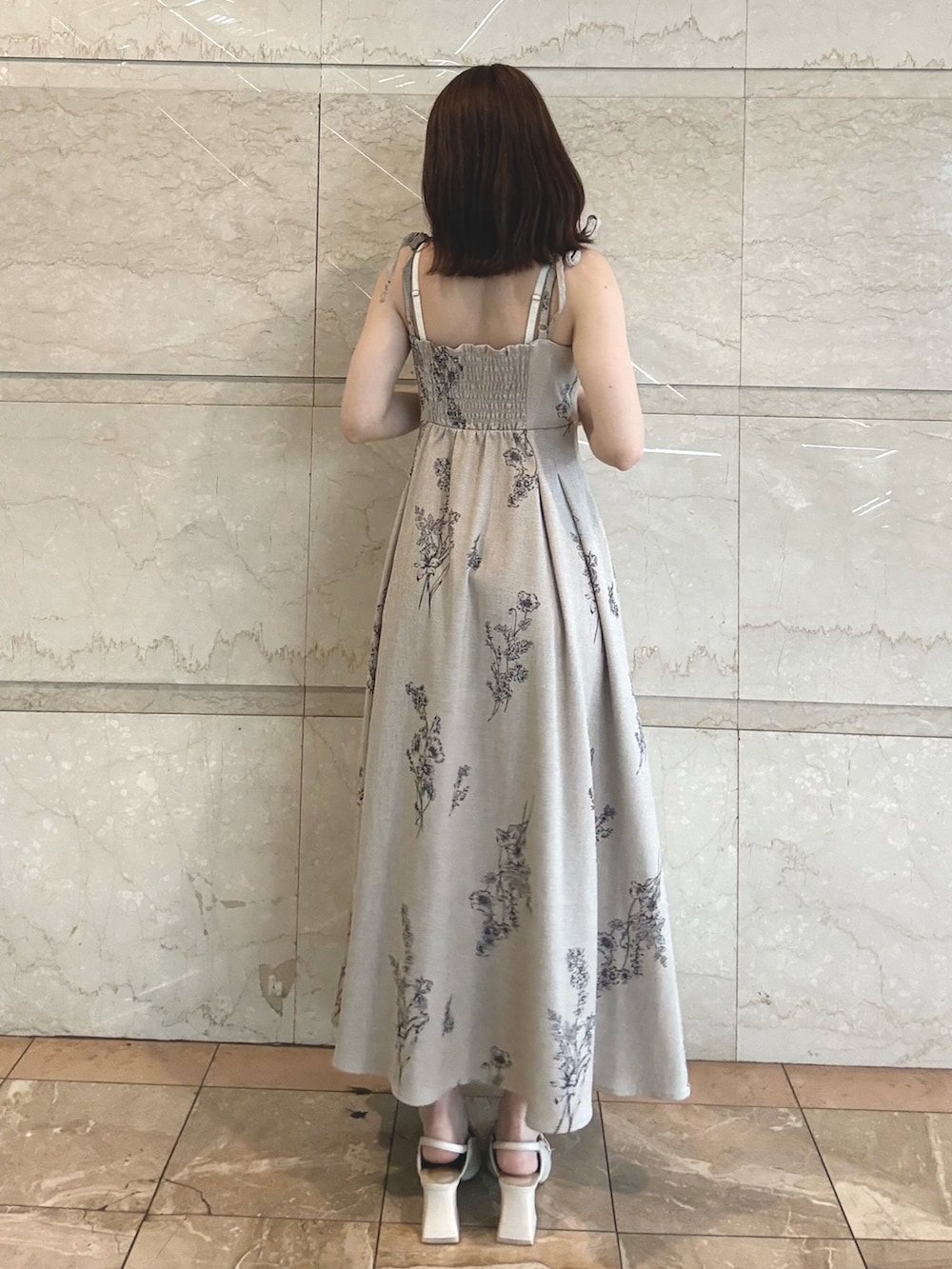 ホワイト系のカーディガン/ボレロ、ベージュ系のワンピース、ホワイト系のパンプスを着用したレディースの春コーディネートの4枚目の写真