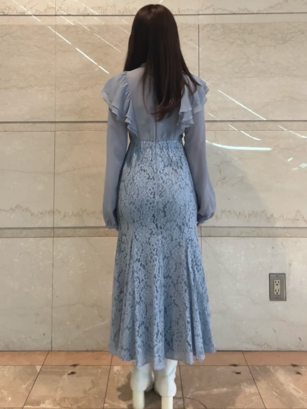 ブルー系のドレス、ホワイト系のブーツを着用したレディースの冬コーディネートの4枚目の写真