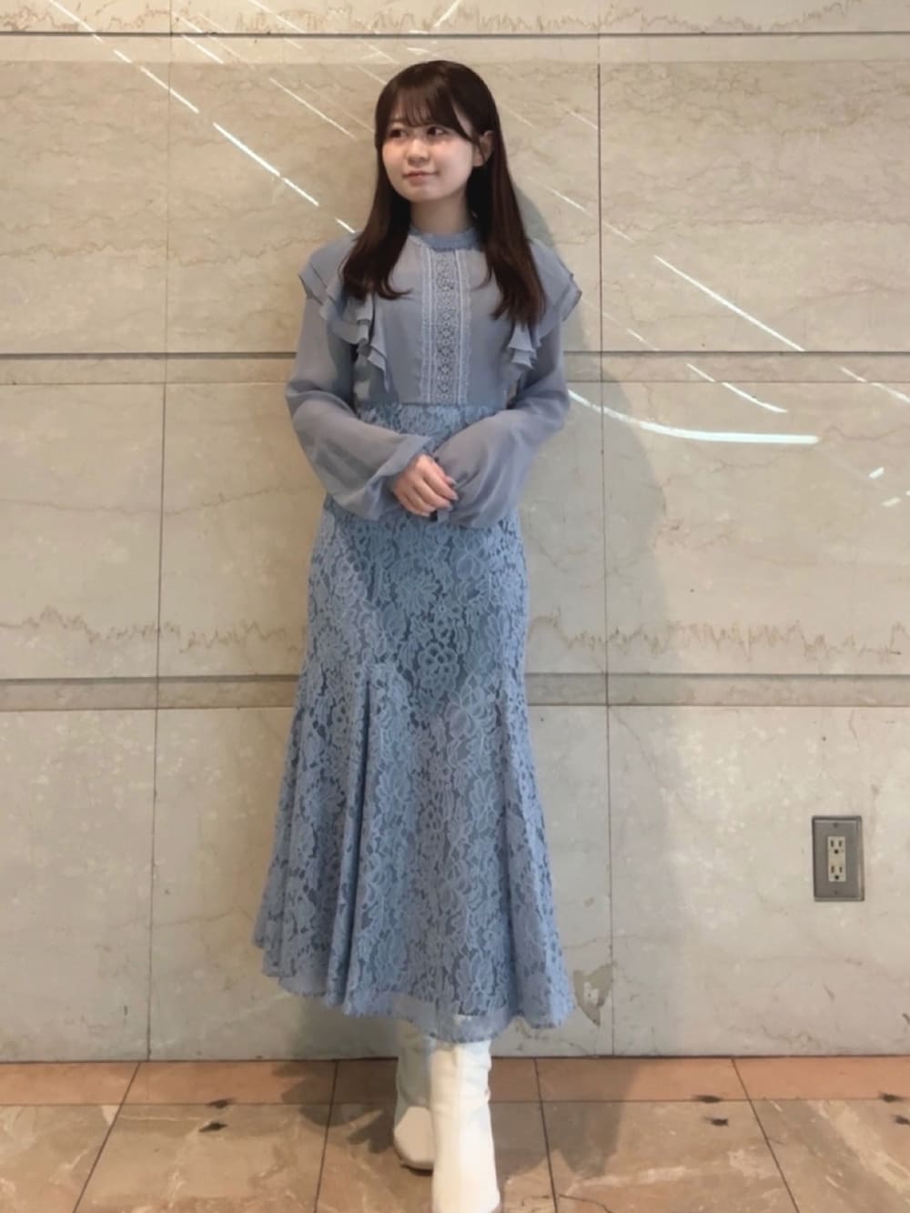 ブルー系のドレス、ホワイト系のブーツを着用したレディースの冬コーディネートの2枚目の写真