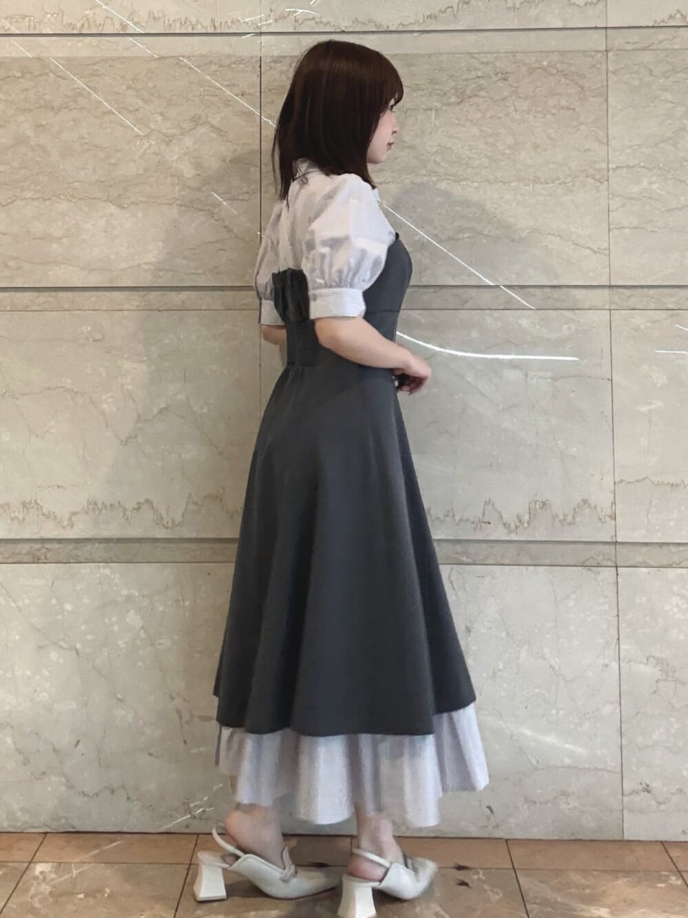 ホワイト系のパンプス、グレー系のワンピースを着用したレディースの春コーディネートの3枚目の写真