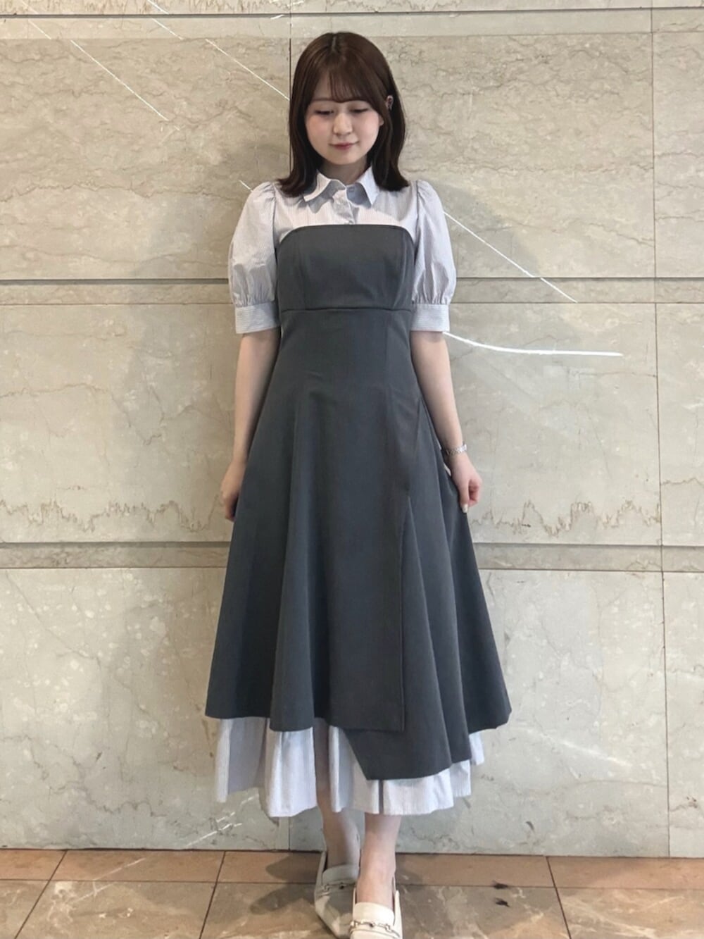 ホワイト系のパンプス、グレー系のワンピースを着用したレディースの春コーディネートの2枚目の写真