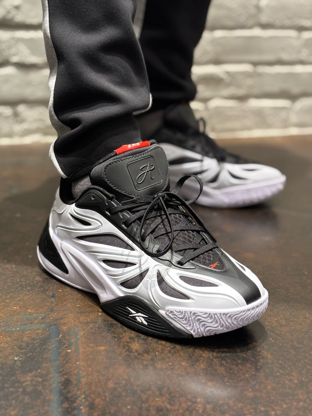 ホワイト系のスニーカー、ブラック系のトップス、ホワイト系のTシャツ/カットソーを着用したメンズの冬コーディネートの5枚目の写真