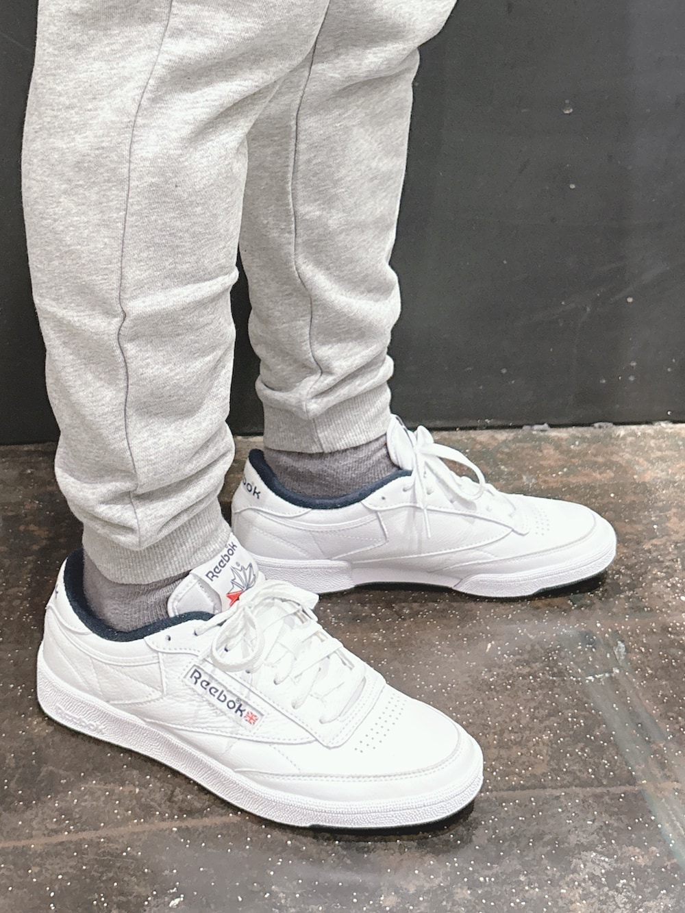 ホワイト系のスニーカー、グレー系のスウェットパンツ、ブルー系のナイロンジャケットを着用したメンズの春コーディネートの3枚目の写真