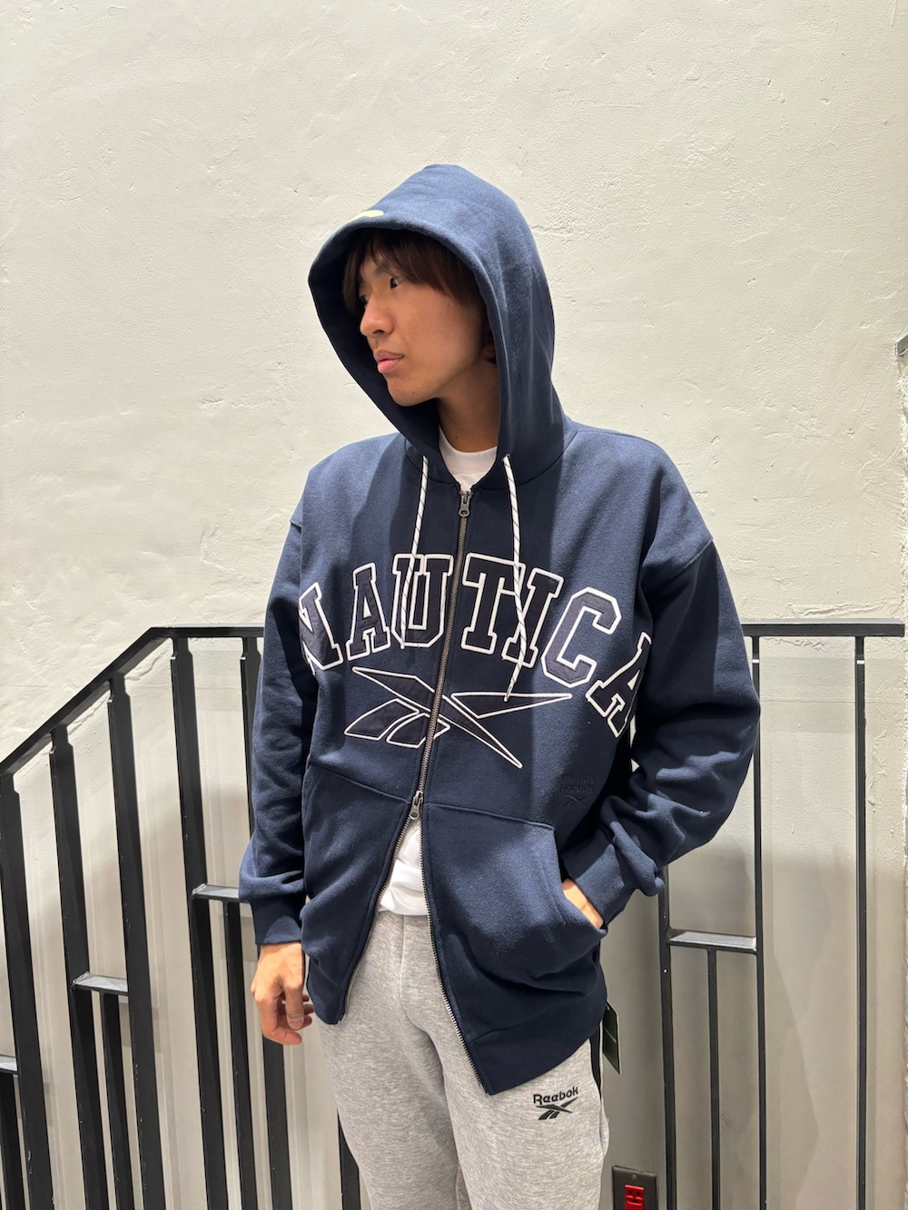 ホワイト系のスニーカー、ブラック系のトップス、ホワイト系のTシャツ/カットソーを着用したメンズの冬コーディネートの3枚目の写真