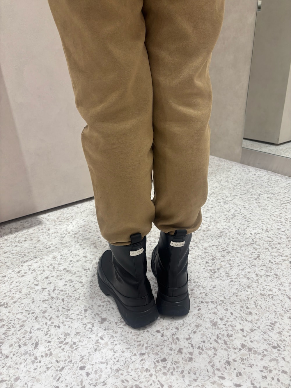 ブラック系のレインシューズを着用したレディースの冬コーディネートの3枚目の写真