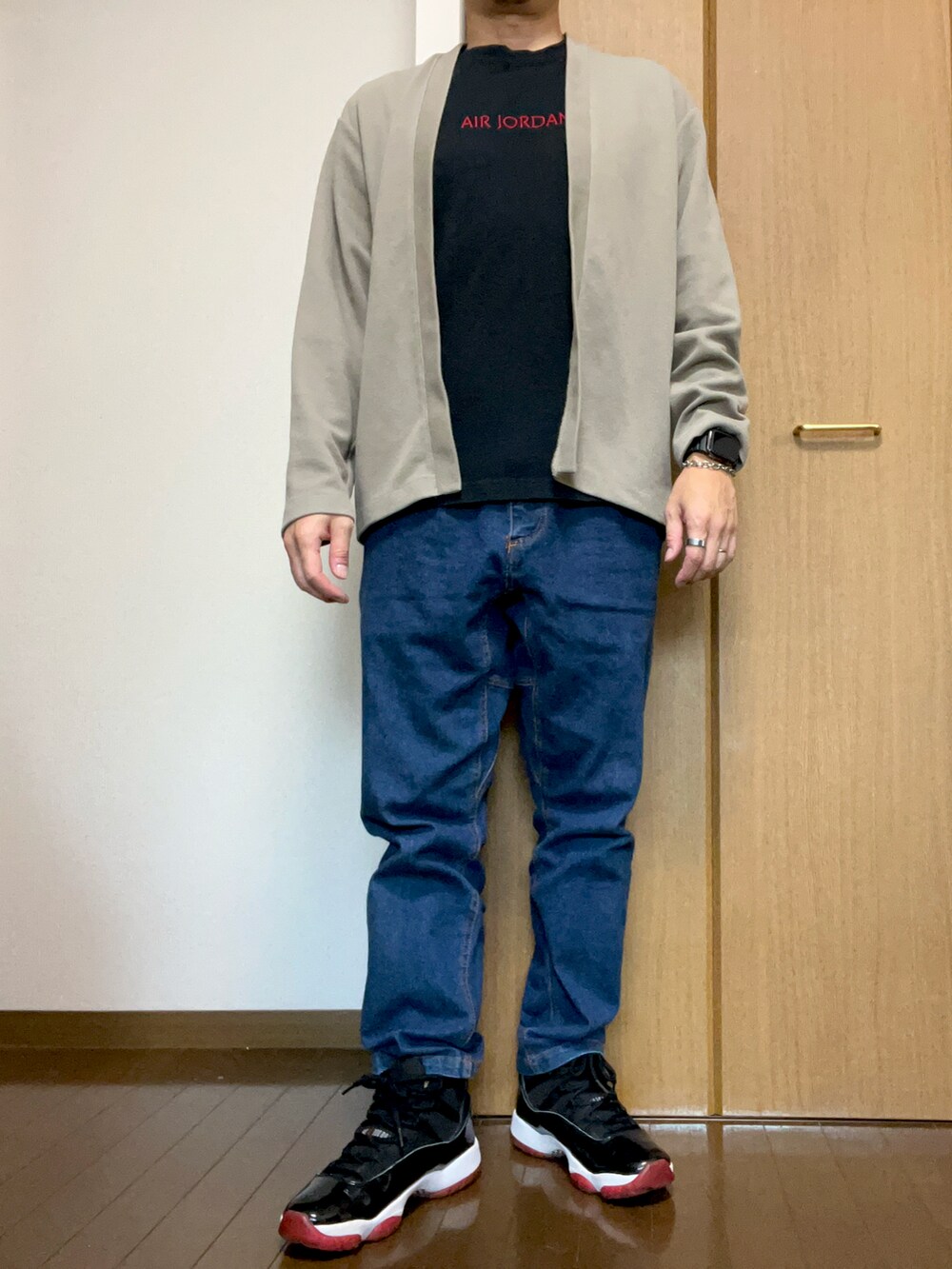 グレー系のカーディガン/ボレロ、ブルー系のチノパンツ、ブラック系のTシャツ/カットソーを着用したメンズの秋コーディネートの2枚目の写真