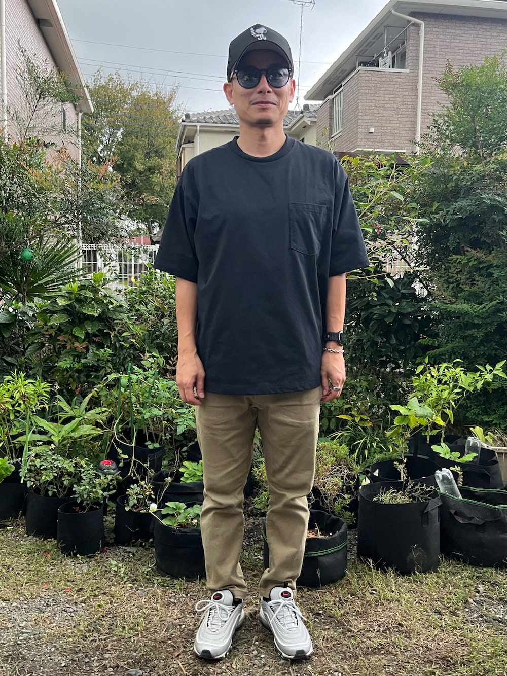 ブラック系のTシャツ/カットソー、ベージュ系のチノパンツ、シルバー系のスニーカーを着用したメンズの秋コーディネートの3枚目の写真