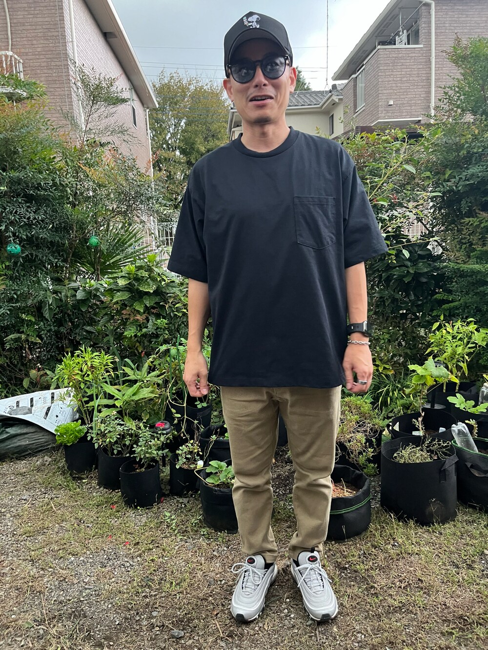 ブラック系のTシャツ/カットソー、ベージュ系のチノパンツ、シルバー系のスニーカーを着用したメンズの秋コーディネートの2枚目の写真