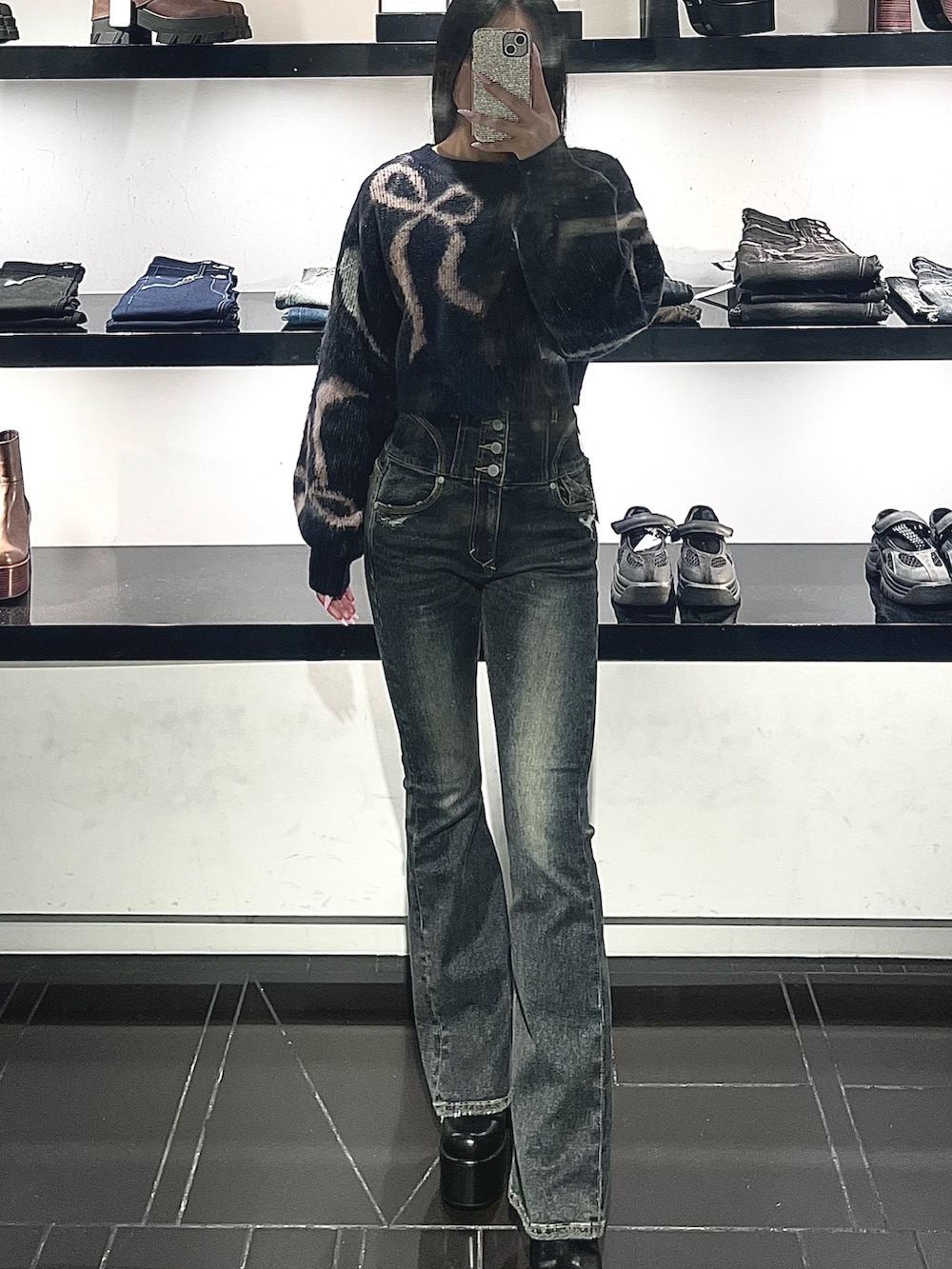 ブルー系のデニムパンツ、ブルー系のニット/セーター、ブラック系のハンドバッグを着用したレディースの秋コーディネートの6枚目の写真