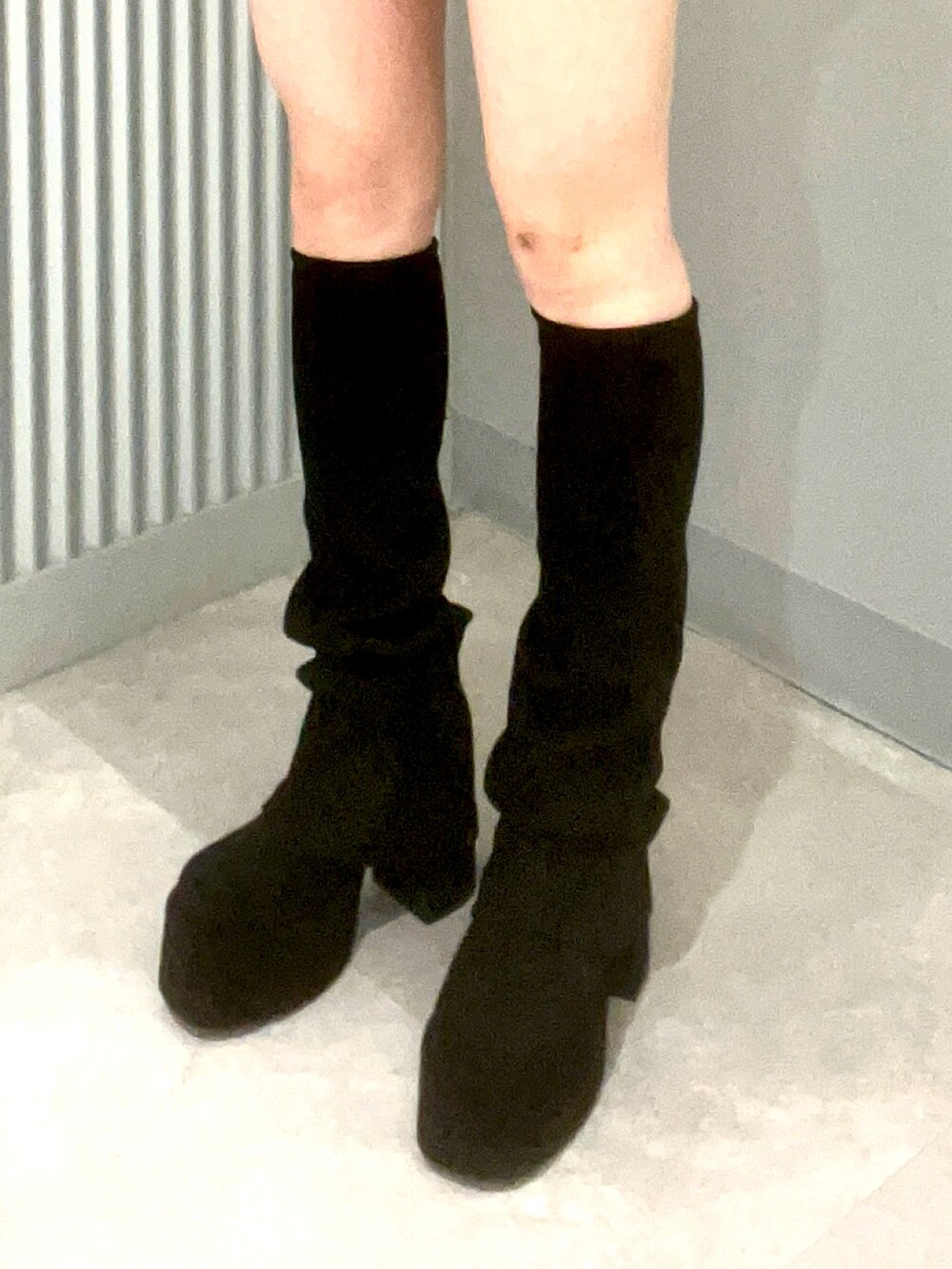 ブラック系のハンドバッグ、ブラック系のブーツ、ブラウン系のスカートを着用したレディースの秋コーディネートの4枚目の写真