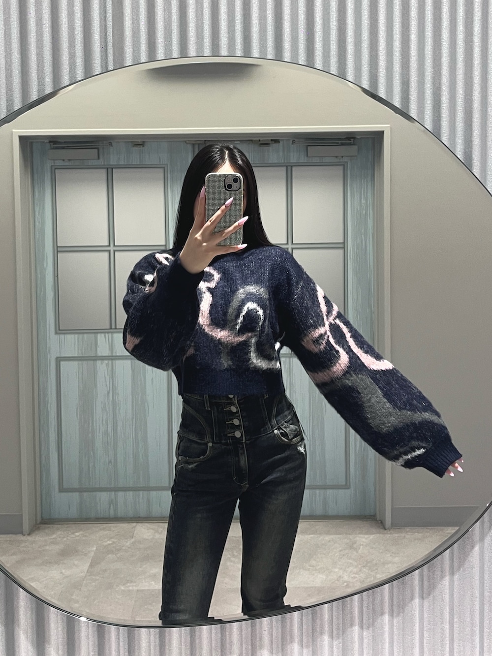 ブルー系のデニムパンツ、ブルー系のニット/セーター、ブラック系のハンドバッグを着用したレディースの秋コーディネートの7枚目の写真