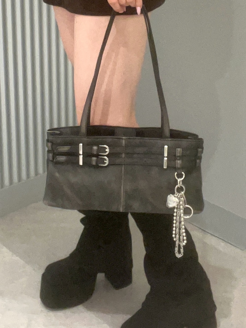 ブラック系のハンドバッグ、ブラック系のブーツ、ブラウン系のスカートを着用したレディースの秋コーディネートの5枚目の写真