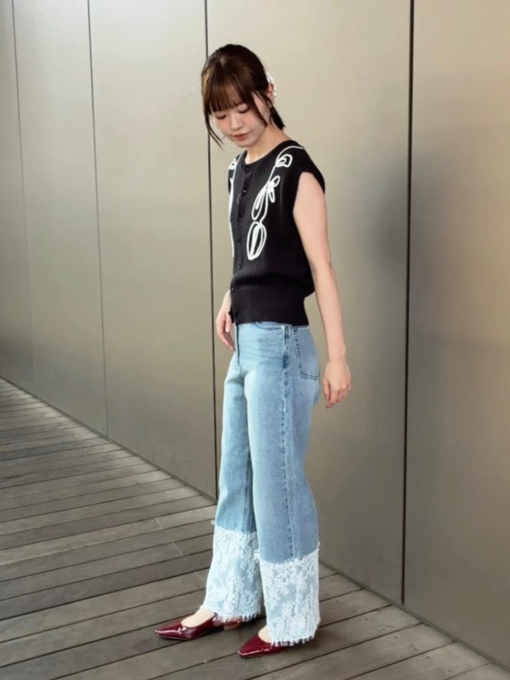 グレー系のベスト、ブルー系のデニムパンツを着用したレディースの夏コーディネートの4枚目の写真