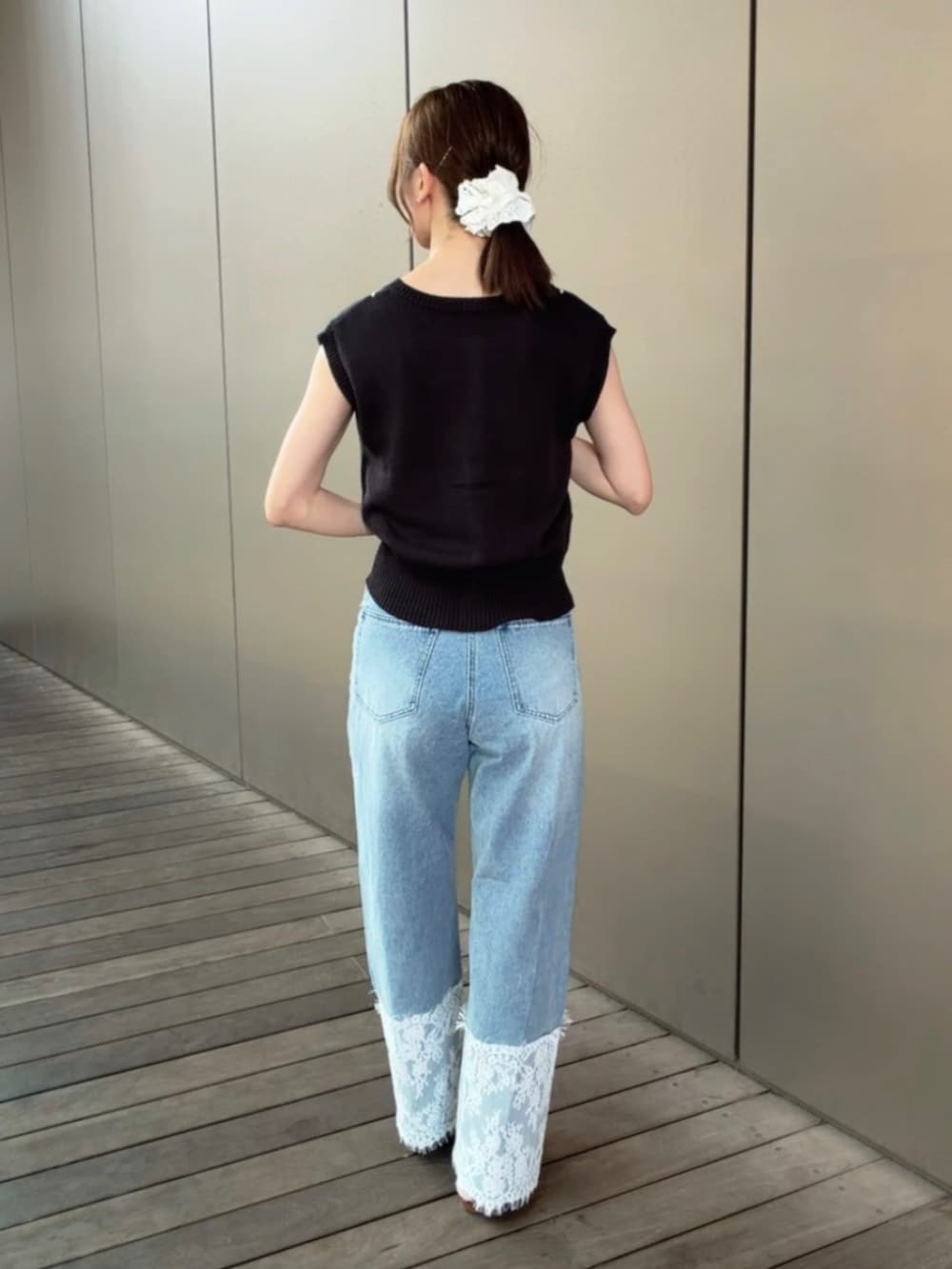 グレー系のベスト、ブルー系のデニムパンツを着用したレディースの夏コーディネートの5枚目の写真