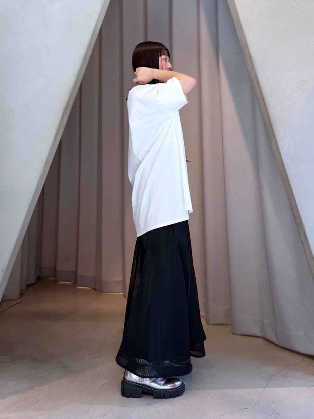 ホワイト系のTシャツ/カットソー、ブラック系のスカート、シルバー系のブーツを着用したレディースの夏コーディネートの6枚目の写真