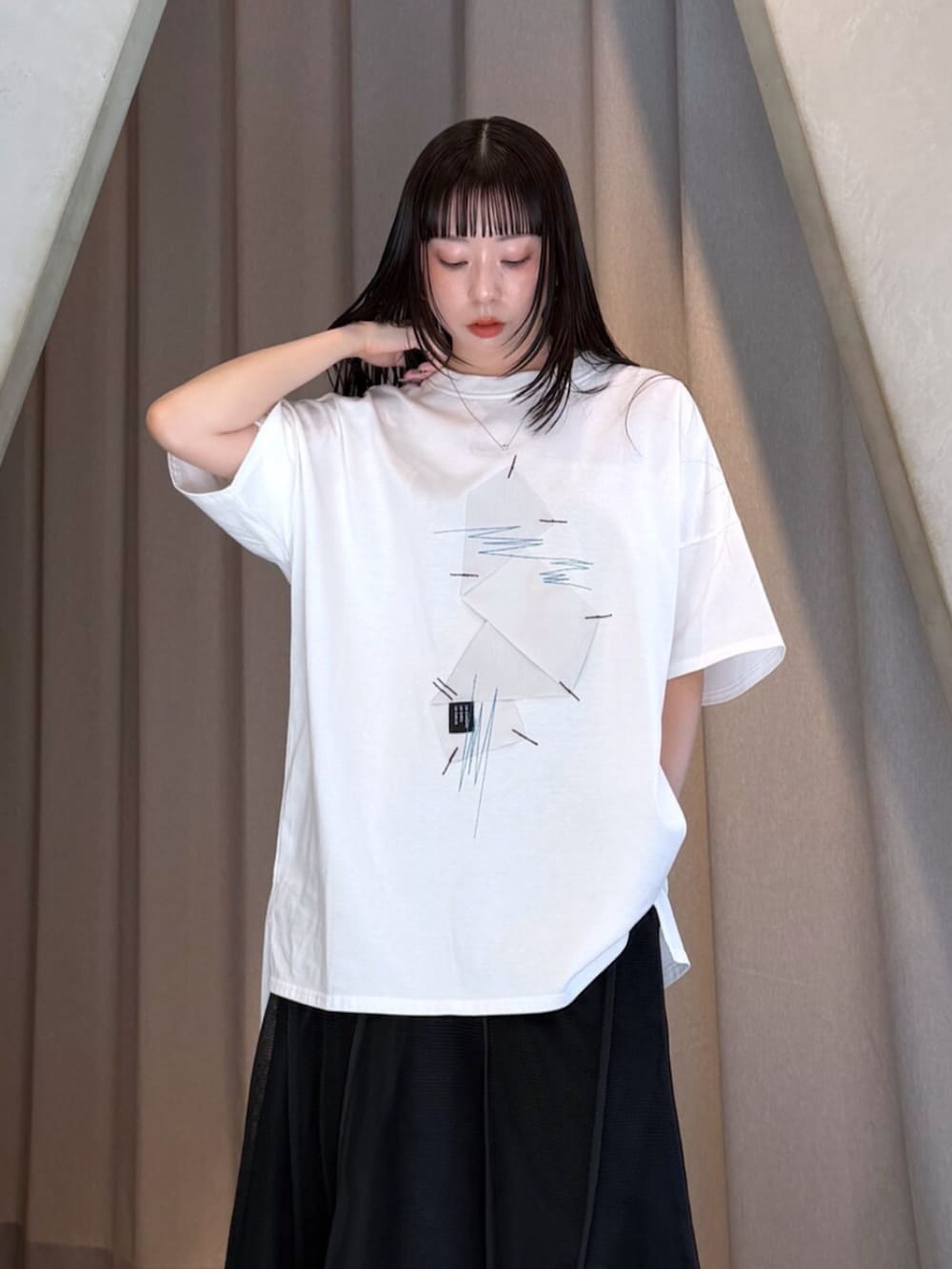ホワイト系のTシャツ/カットソー、ブラック系のスカート、シルバー系のブーツを着用したレディースの夏コーディネートの7枚目の写真