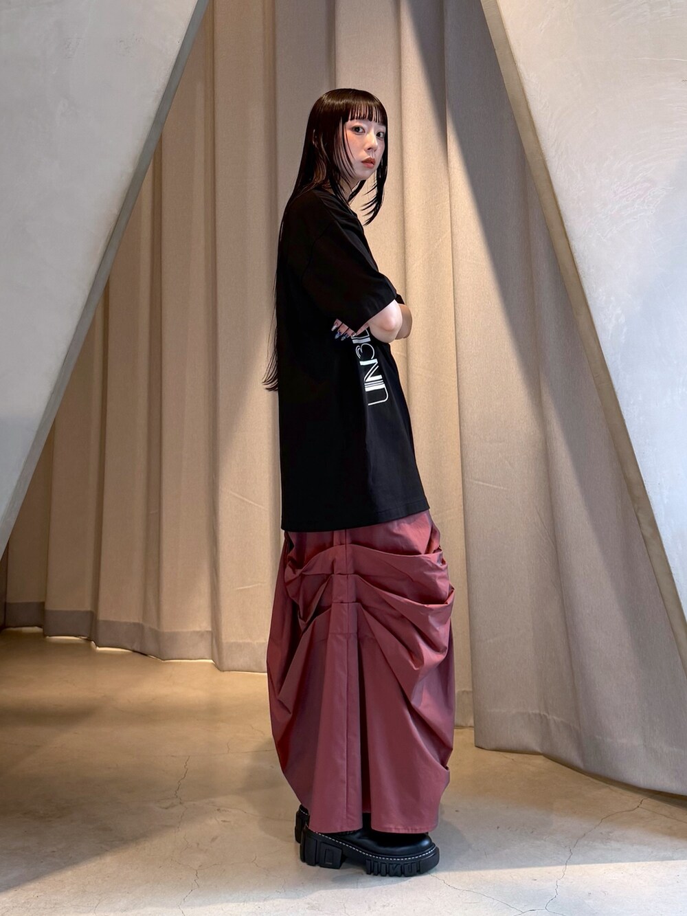 ブラック系のTシャツ/カットソー、レッド系のスカート、ブラック系のブーツを着用したレディースの秋コーディネートの4枚目の写真