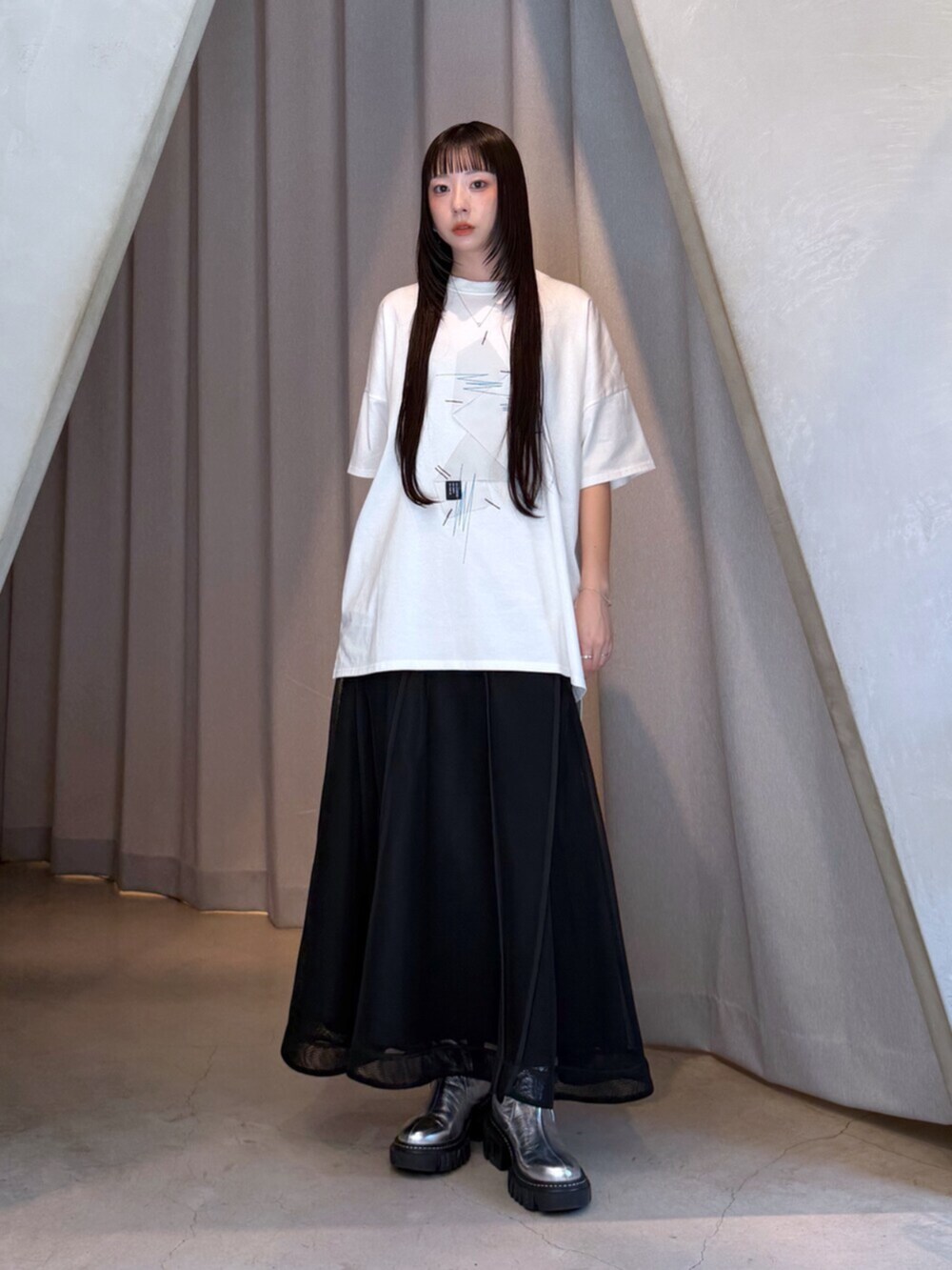 ホワイト系のTシャツ/カットソー、ブラック系のスカート、シルバー系のブーツを着用したレディースの夏コーディネートの9枚目の写真