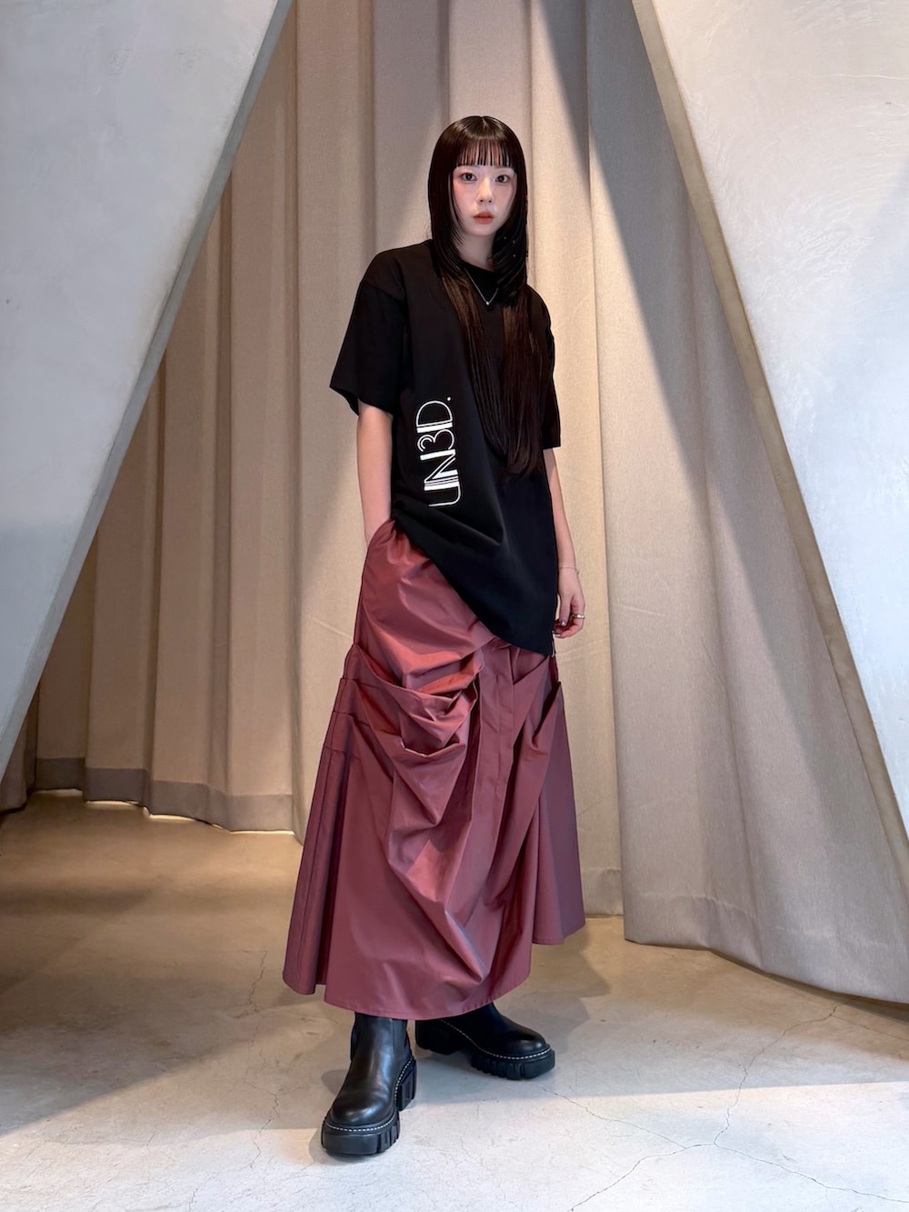 ブラック系のTシャツ/カットソー、レッド系のスカート、ブラック系のブーツを着用したレディースの秋コーディネートの5枚目の写真