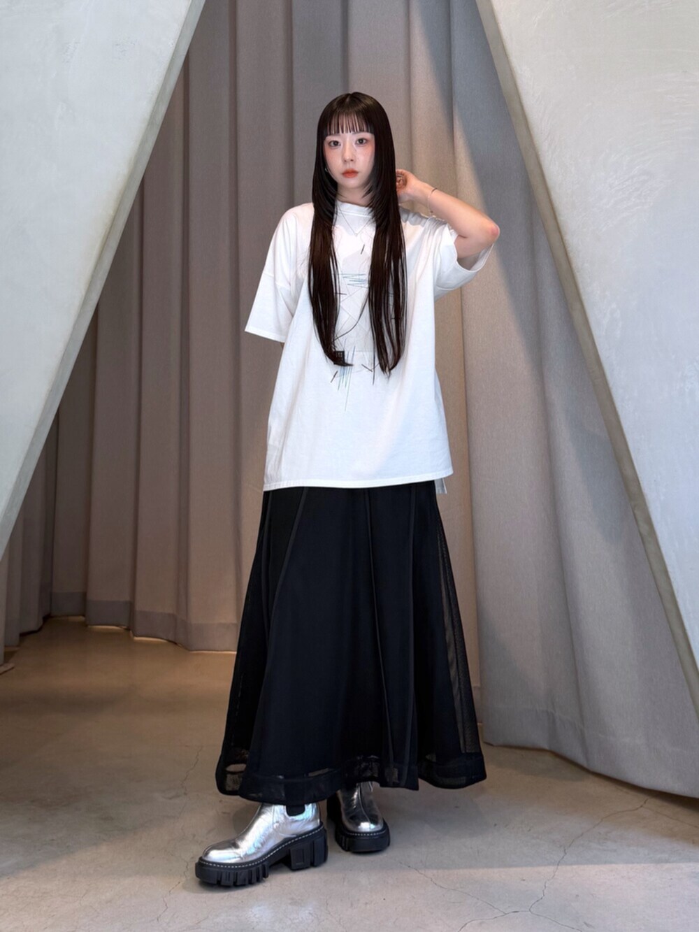 ホワイト系のTシャツ/カットソー、ブラック系のスカート、シルバー系のブーツを着用したレディースの夏コーディネートの2枚目の写真