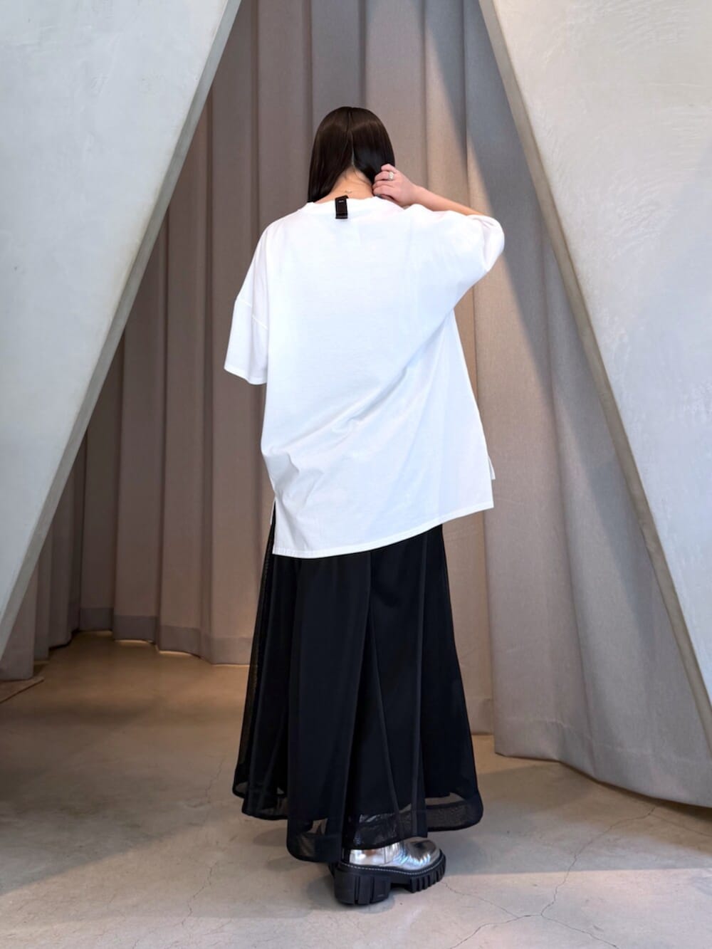 ホワイト系のTシャツ/カットソー、ブラック系のスカート、シルバー系のブーツを着用したレディースの夏コーディネートの4枚目の写真