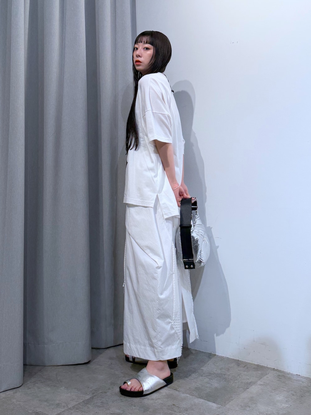 ホワイト系のTシャツ/カットソー、シルバー系のサンダル、ホワイト系のスカートを着用したレディースの夏コーディネートの3枚目の写真