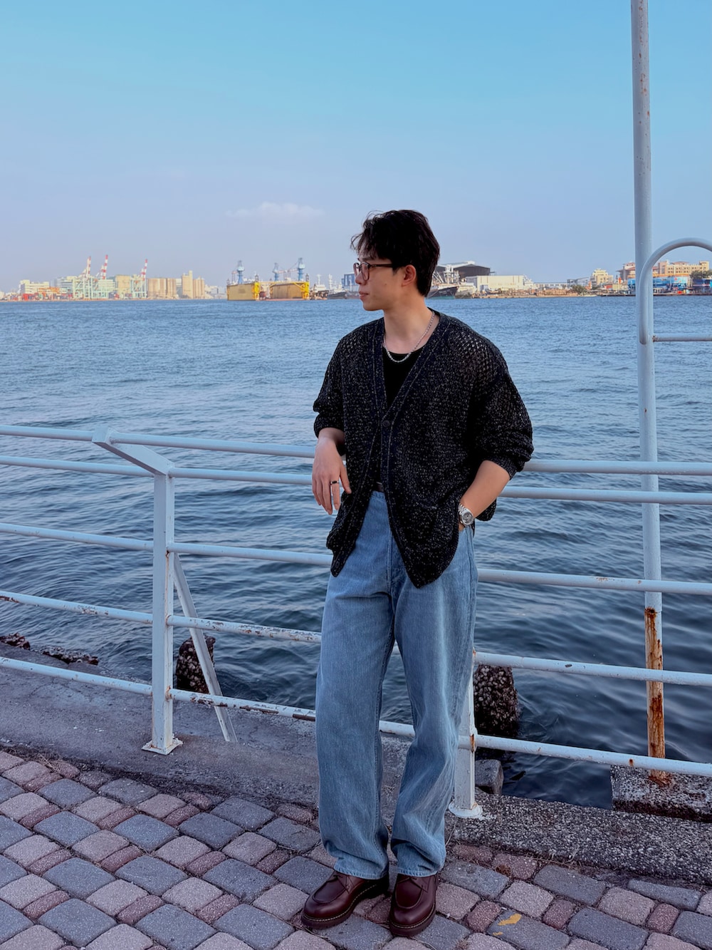 ブラック系のノーカラージャケット、ブルー系のデニムパンツ、ブラウン系のローファーを着用したメンズの春コーディネートの2枚目の写真