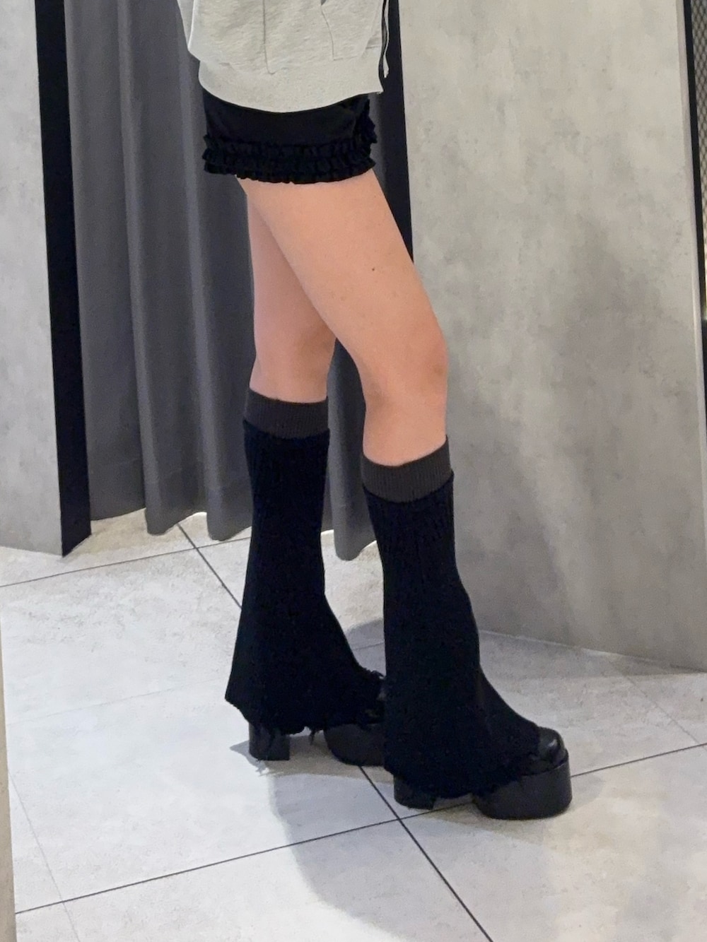 グレー系のパーカー、ブラック系のその他パンツ、ブラック系のレッグウォーマーを着用したレディースの秋コーディネートの5枚目の写真