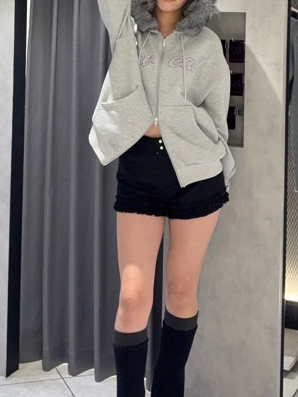グレー系のパーカー、ブラック系のその他パンツ、ブラック系のレッグウォーマーを着用したレディースの秋コーディネートの4枚目の写真