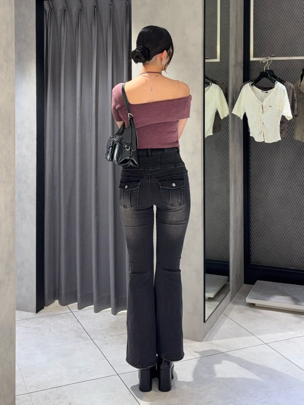 ブラック系のハンドバッグ、レッド系のニット/セーター、ブラック系のデニムパンツを着用したレディースの秋コーディネートの3枚目の写真