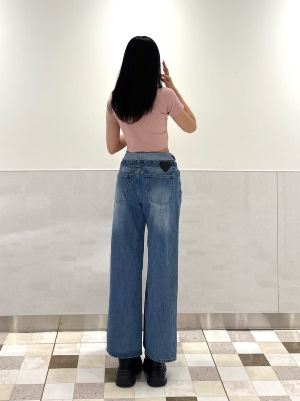 ピンク系のショルダーバッグ、ブルー系のデニムパンツ、ブラック系のスニーカーを着用したレディースの夏コーディネートの3枚目の写真