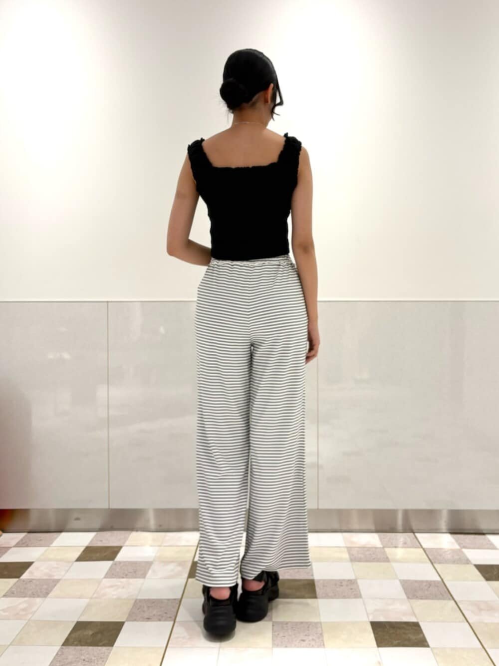 ブラック系のタンクトップ、ホワイト系のその他パンツ、ブラック系のサンダルを着用したレディースの夏コーディネートの3枚目の写真
