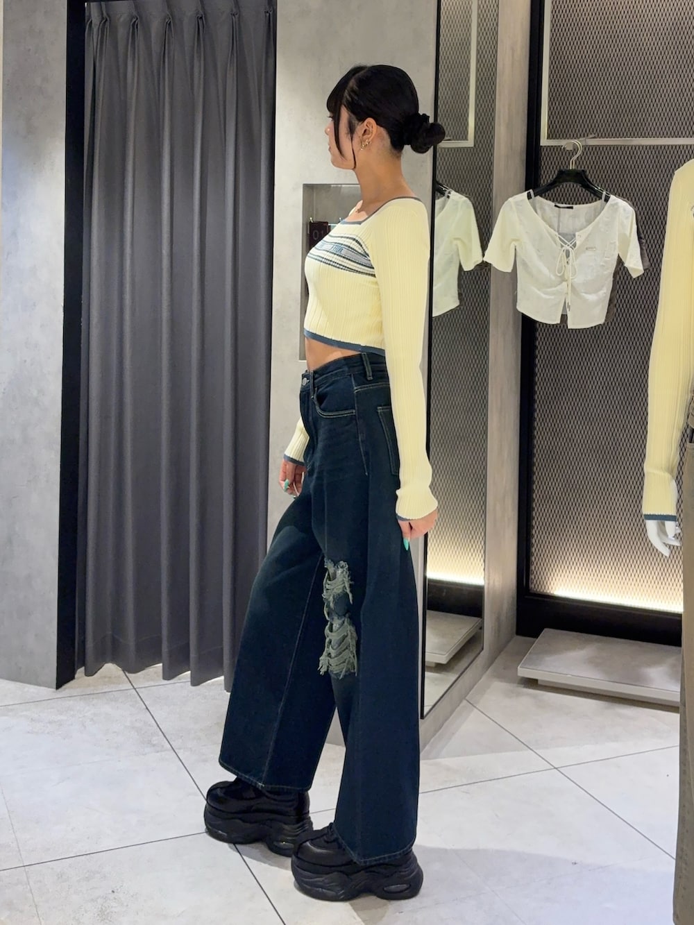 ホワイト系のニット/セーター、ブルー系のデニムパンツ、ブラック系のスニーカーを着用したレディースの秋コーディネートの2枚目の写真