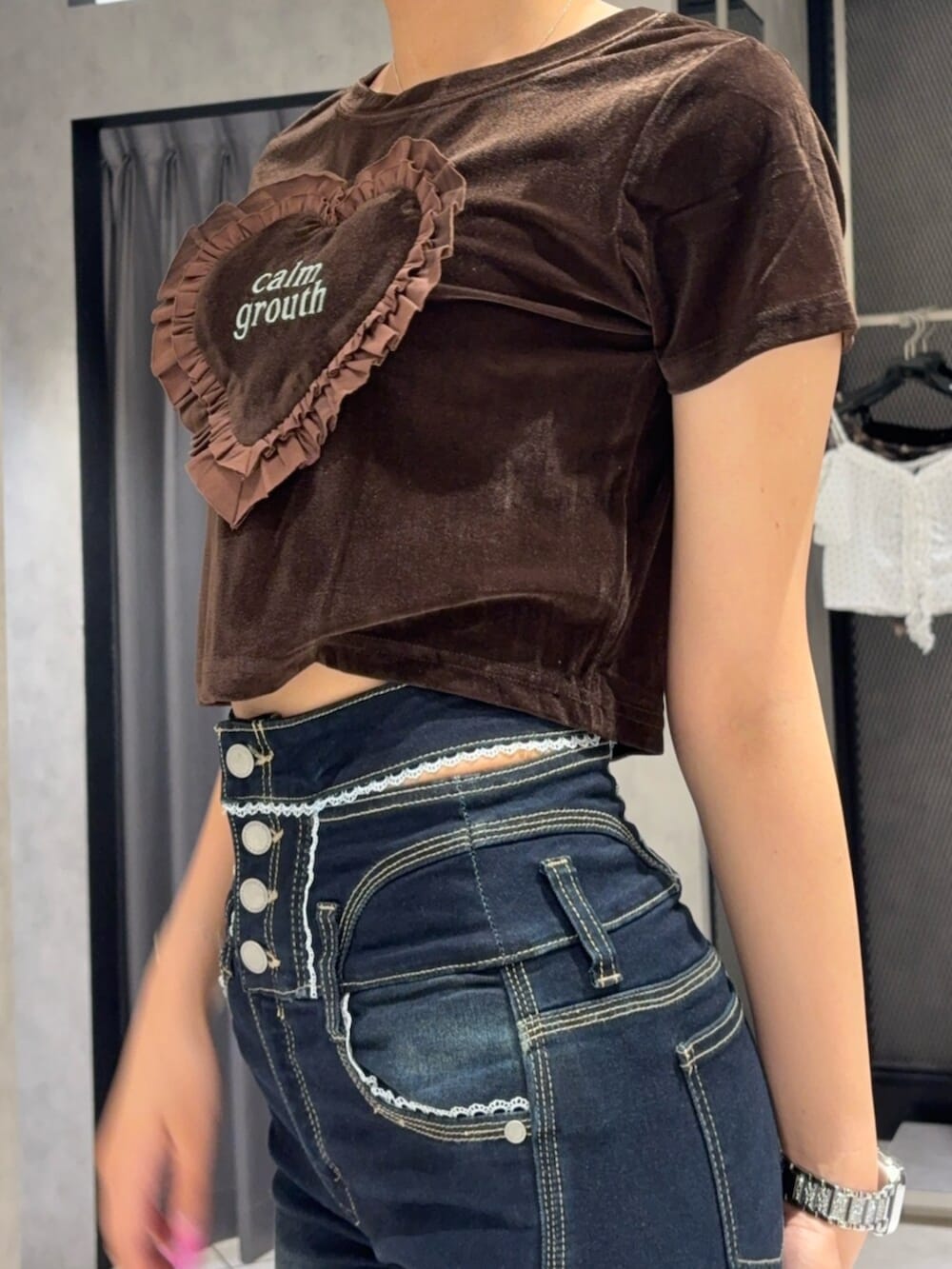 ブラック系のサンダル、ブラック系のハンドバッグ、ブルー系のデニムパンツを着用したレディースの夏コーディネートの5枚目の写真