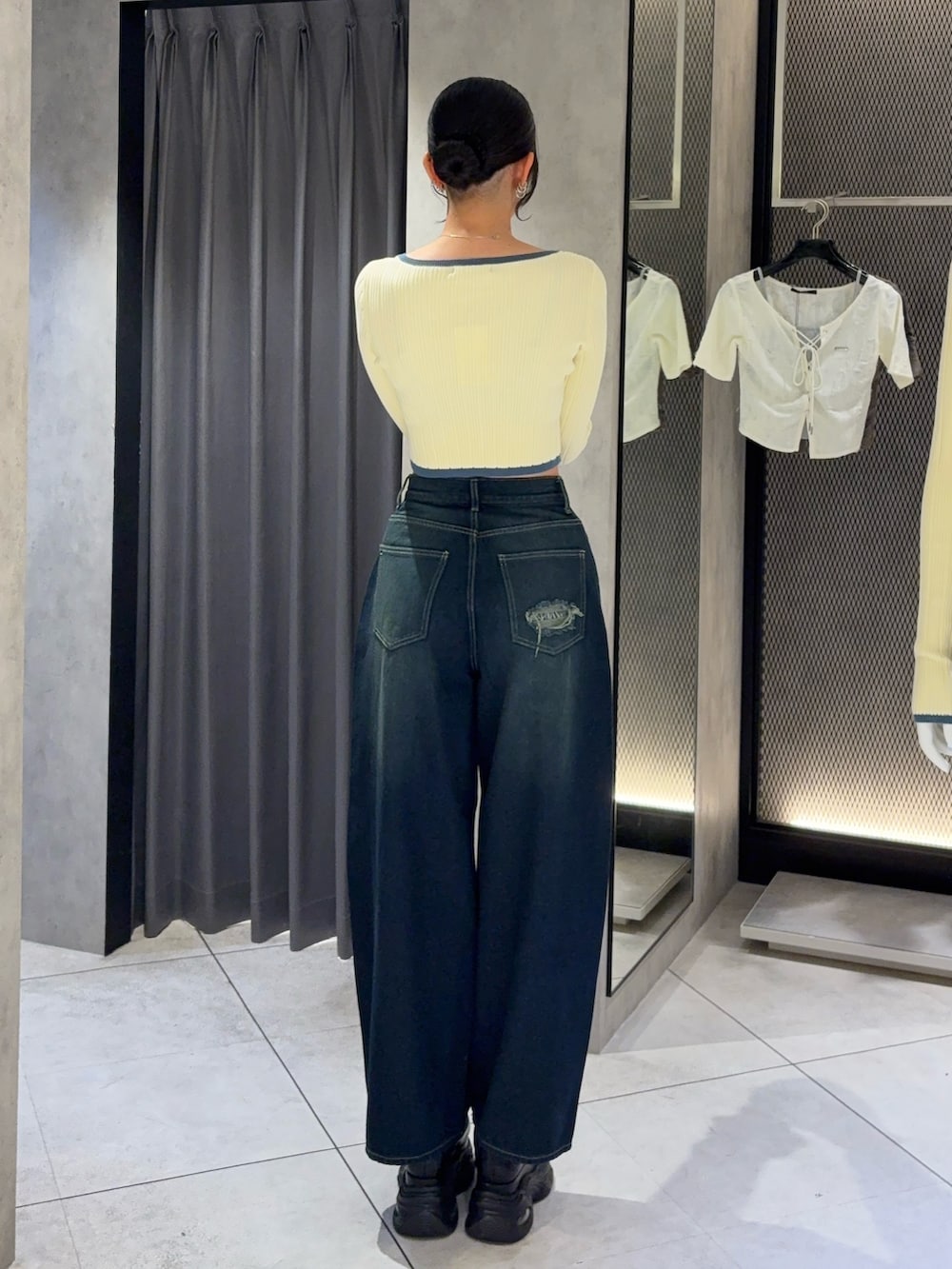 ホワイト系のニット/セーター、ブルー系のデニムパンツ、ブラック系のスニーカーを着用したレディースの秋コーディネートの3枚目の写真