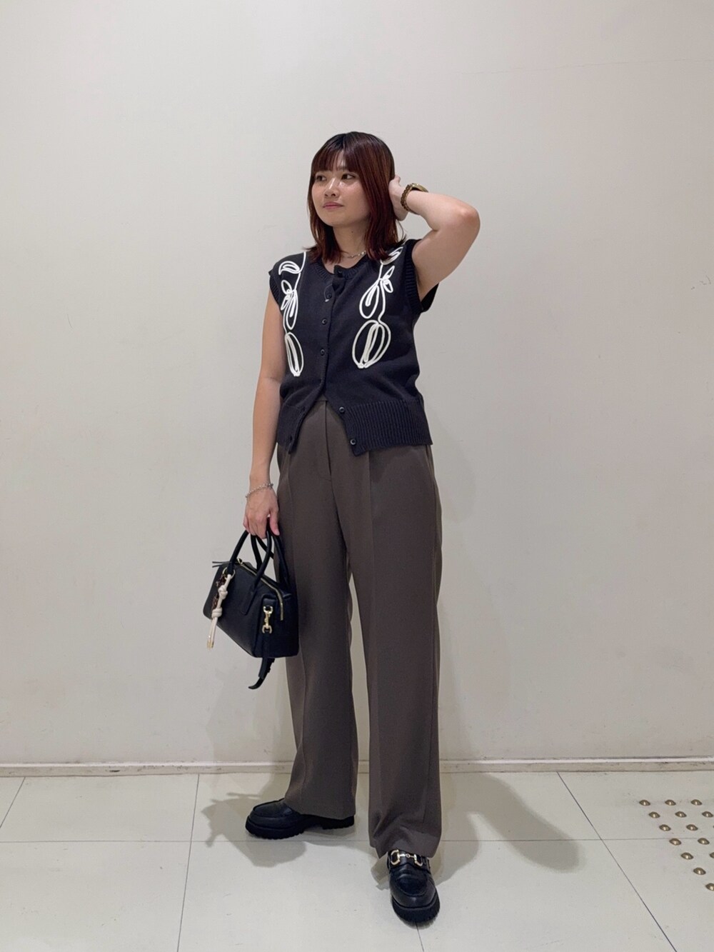 ブラウン系のその他パンツ、ブラック系のローファー、ブラック系のボストンバッグを着用したレディースの秋コーディネートの2枚目の写真