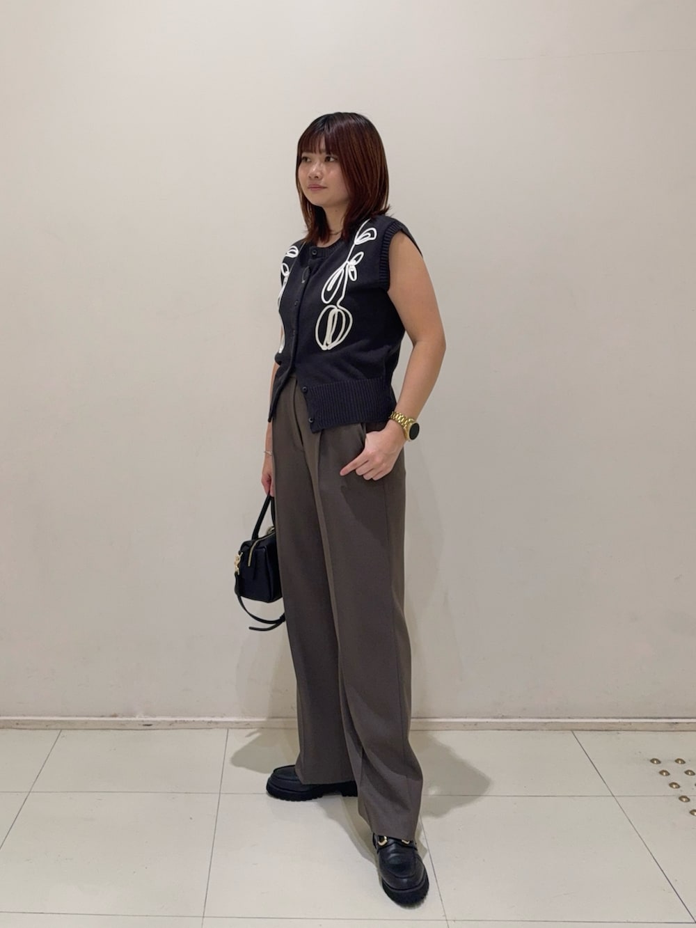 ブラウン系のその他パンツ、ブラック系のローファー、ブラック系のボストンバッグを着用したレディースの秋コーディネートの5枚目の写真