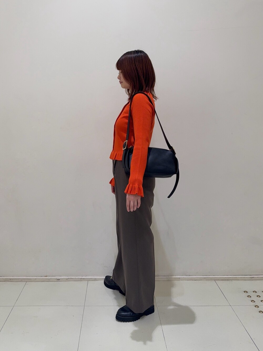ブラウン系のその他パンツ、ブラック系のローファー、オレンジ系のニット/セーターを着用したレディースの秋コーディネートの5枚目の写真