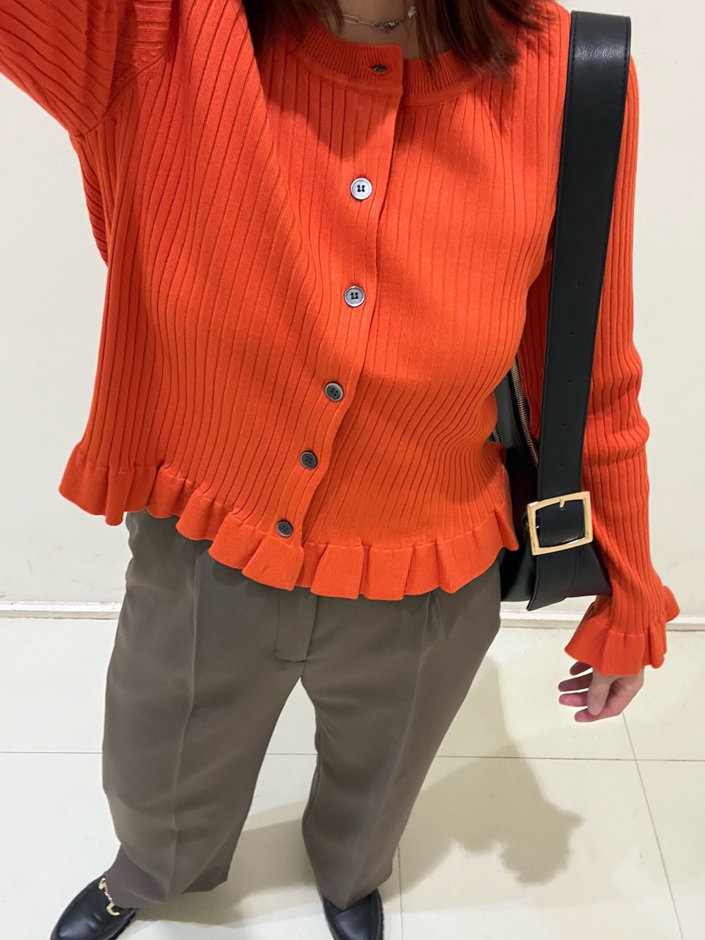 ブラウン系のその他パンツ、ブラック系のローファー、オレンジ系のニット/セーターを着用したレディースの秋コーディネートの7枚目の写真