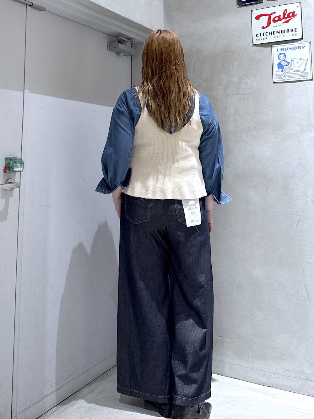 ホワイト系のベスト、ブラック系のパンプス、ブルー系のシャツ/ブラウスを着用したレディースの秋コーディネートの4枚目の写真